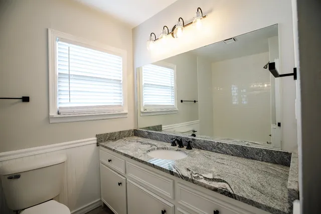 a bathroom with a granite countertop sink and a mirror