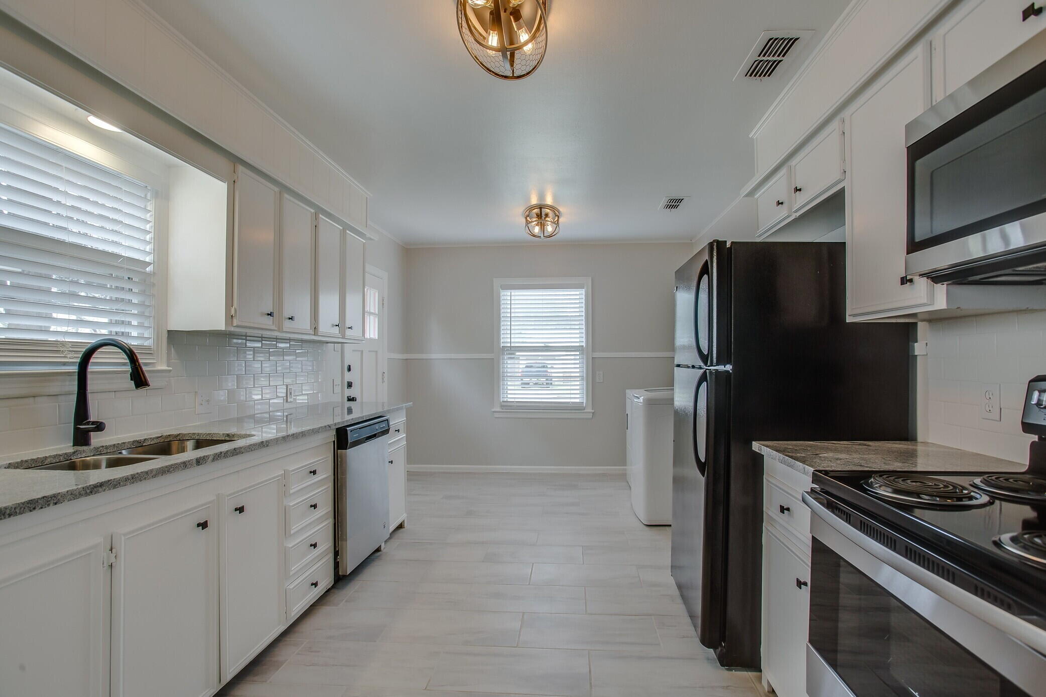 3409 29th Street Lubbock, TX 79410 - Photo 9 of 16 a kitchen with stainless steel appliances granite countertop a refrigerator stove and sink