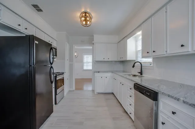 a kitchen with stainless steel appliances granite countertop a refrigerator and a stove