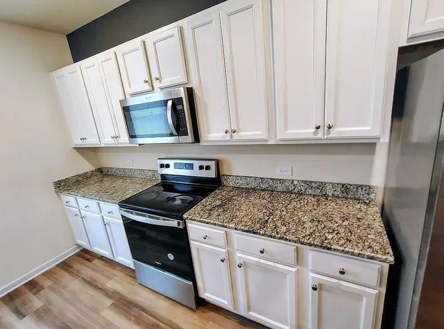 a kitchen with white cabinets sink and stainless steel appliances