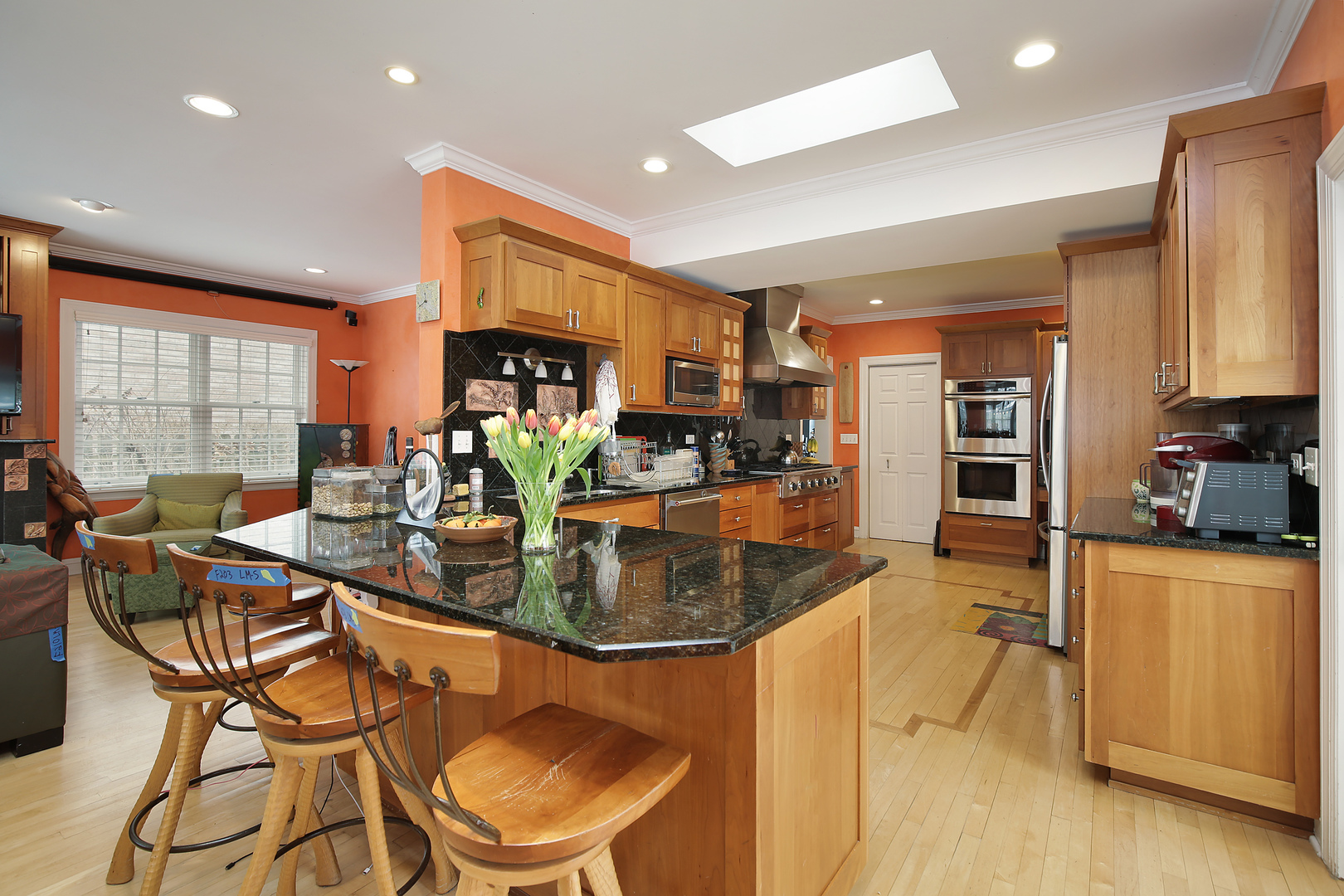 917 Oxford Road Deerfield, IL 60015 - Photo 8 of 19 a kitchen with stainless steel appliances granite countertop a stove a refrigerator a sink a dining table and chairs with wooden floor