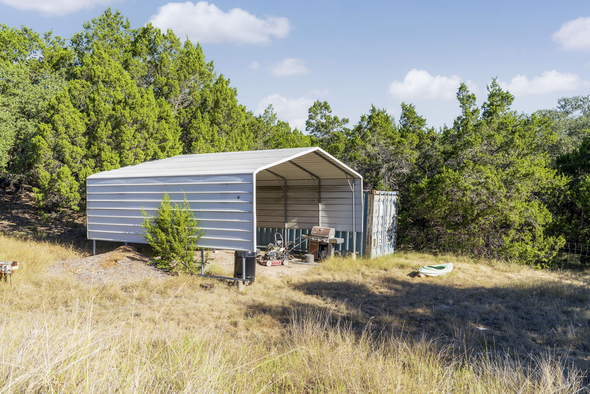 2021 Stagecoach Ranch Road Dripping Springs, TX 78620 - Photo 29 of 35 a backyard of a house with table and chairs under an umbrella