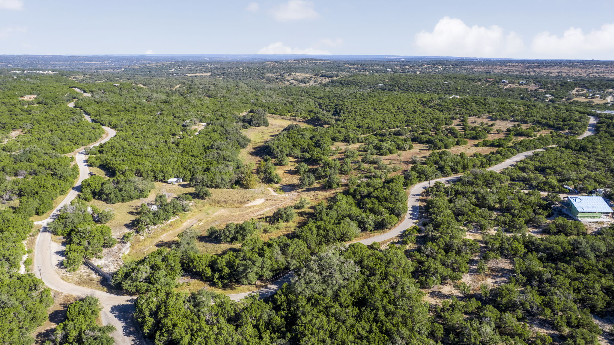 2021 Stagecoach Ranch Road Dripping Springs, TX 78620 - Photo 34 of 35 an aerial view of residential houses with outdoor space and trees
