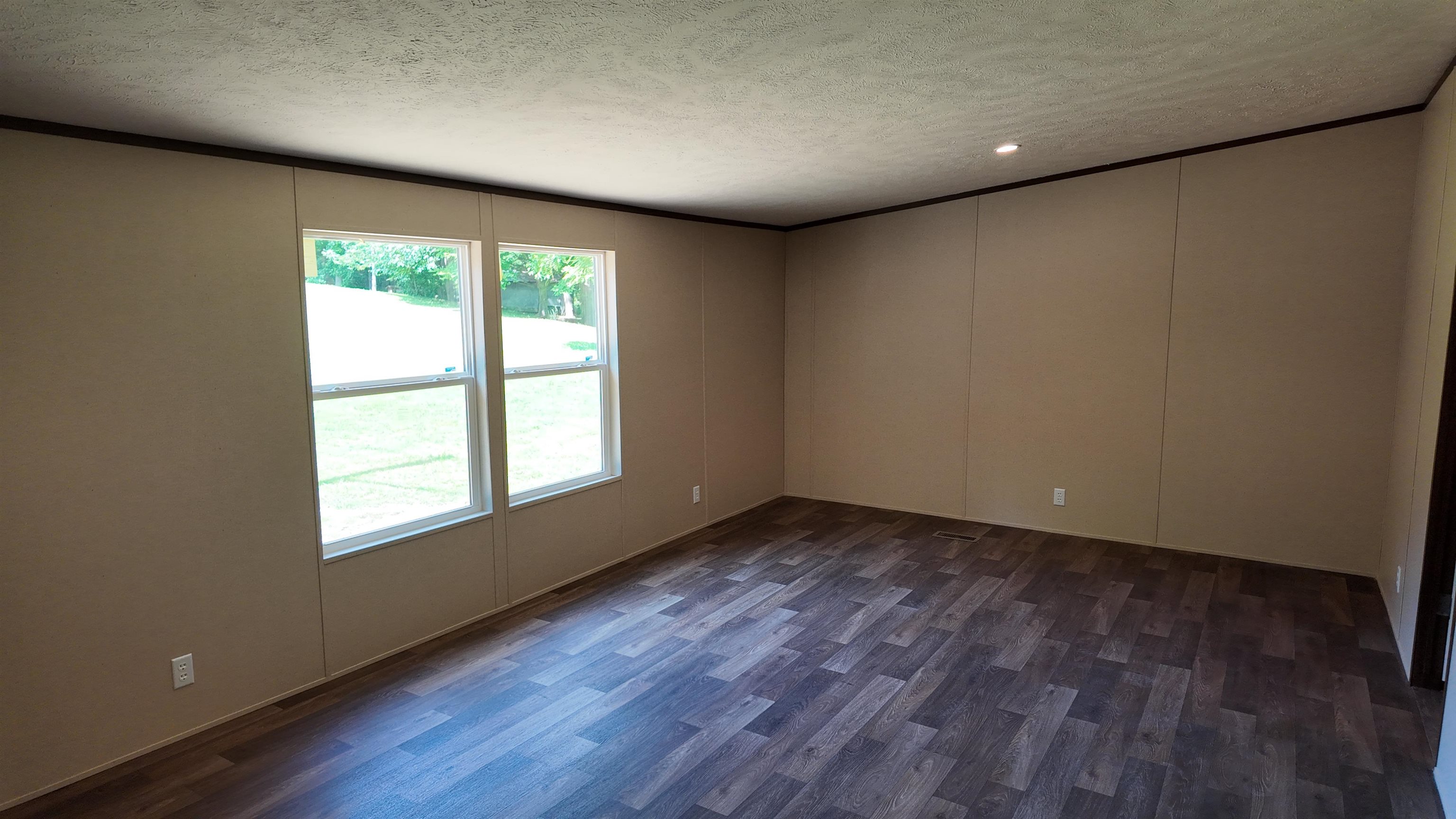 208 Marcy Cove Ripley, TN 38063 - Photo 7 of 14 Spare room with a textured ceiling, crown molding, dark wood-type flooring, and a decorative wall