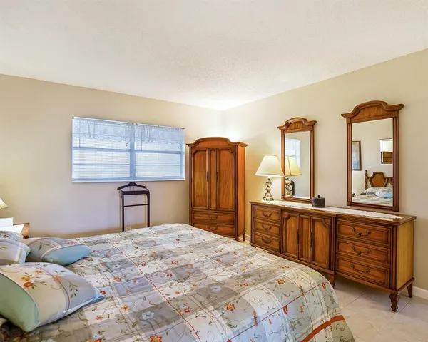 a bedroom with a bed and dresser with mirror