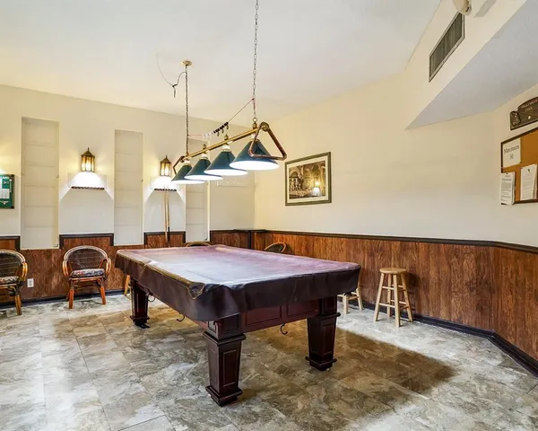 a room with pool table and windows