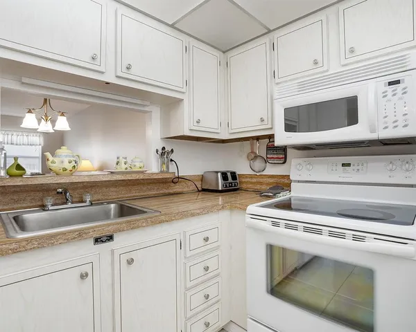 a kitchen with white cabinets and a sink