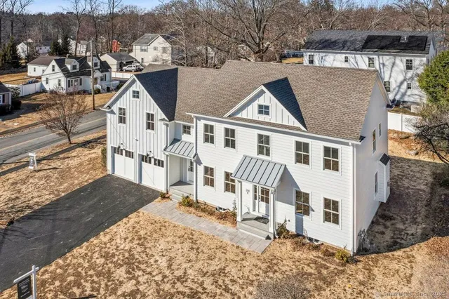 a large kitchen with white cabinets stainless steel appliances and a center island