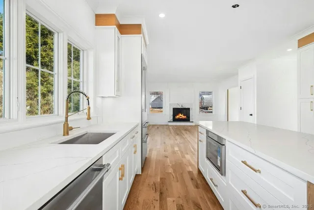 a view of empty room with wooden floor and fireplace