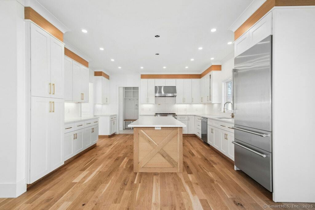 210 Pansy Road Fairfield, CT 06824 - Photo 10 of 14 a large kitchen with white cabinets stainless steel appliances and a center island