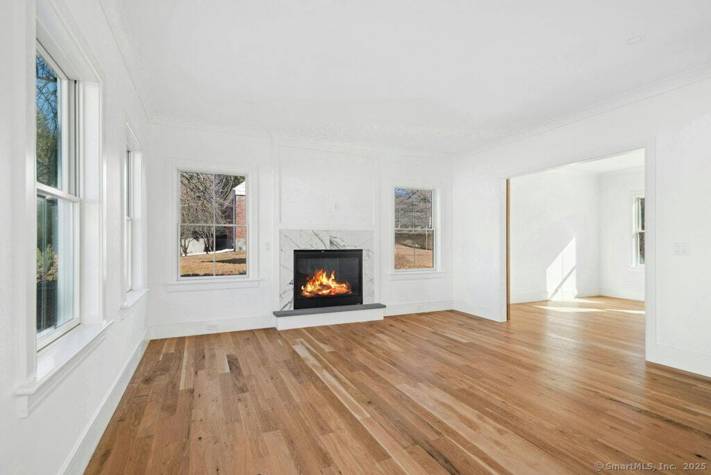 210 Pansy Road Fairfield, CT 06824 - Photo 11 of 14 a view of empty room with wooden floor and fireplace