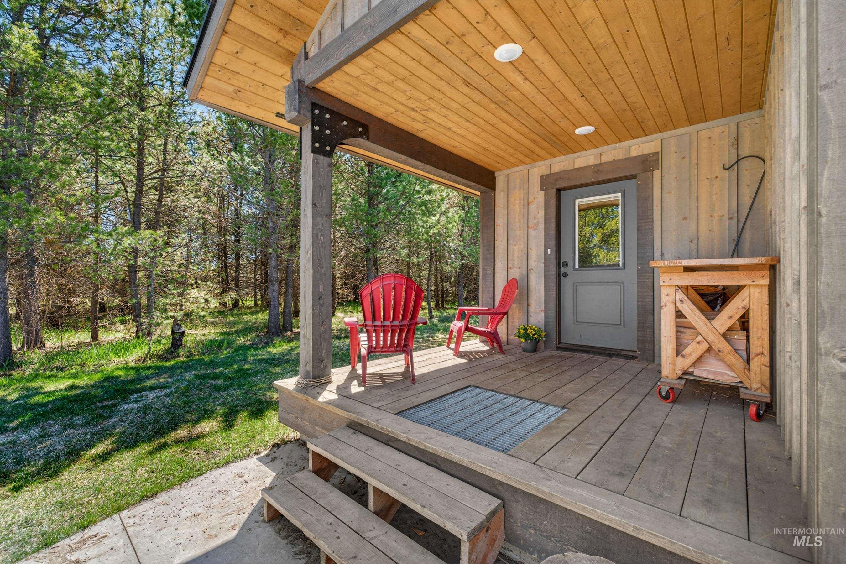 13388 Norwood Road McCall, ID 83638 - Photo 20 of 44 Covered wood-plank porch with a gray entry door, wood-paneled ceiling, and recessed lighting