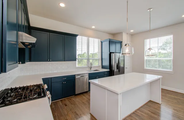 a kitchen with stainless steel appliances granite countertop a sink stove and refrigerator
