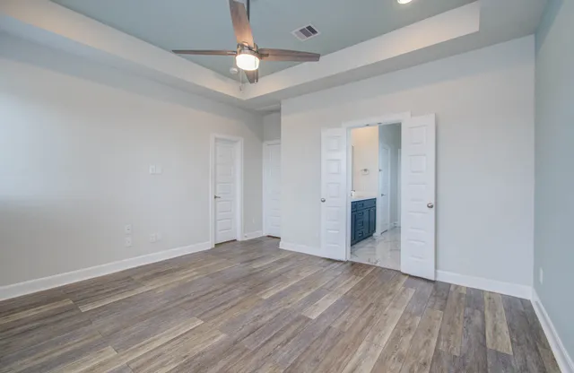 an empty room with wooden floor and windows