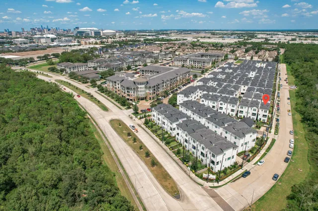 a view of a white house with large windows and potted plants