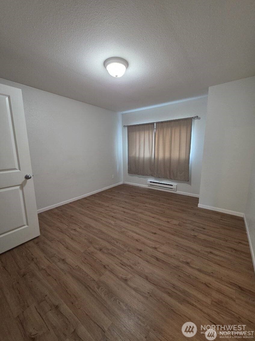 31500 33rd Place Southwest, Unit U101 Federal Way, WA 98023 - Photo 12 of 27 wooden floor in an empty room with a window