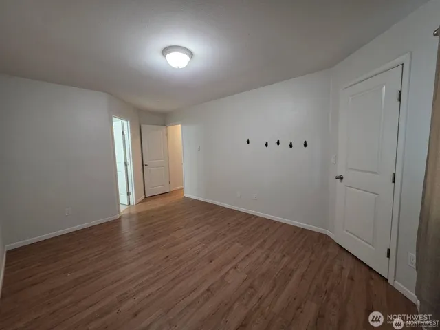 a view of an empty room with wooden floor