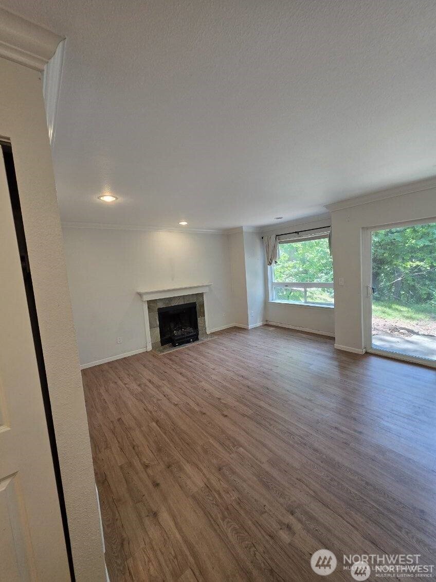 31500 33rd Place Southwest, Unit U101 Federal Way, WA 98023 - Photo 6 of 27 a view of an empty room with wooden floor and a window