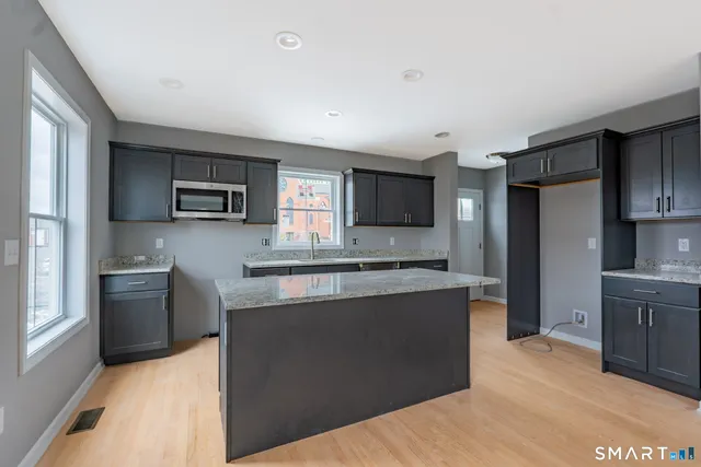 a kitchen with stainless steel appliances granite countertop a refrigerator stove microwave and sink