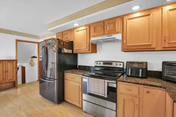 a dining room with furniture a chandelier and wooden floor