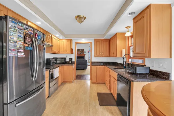 a dining room with furniture a chandelier and wooden floor