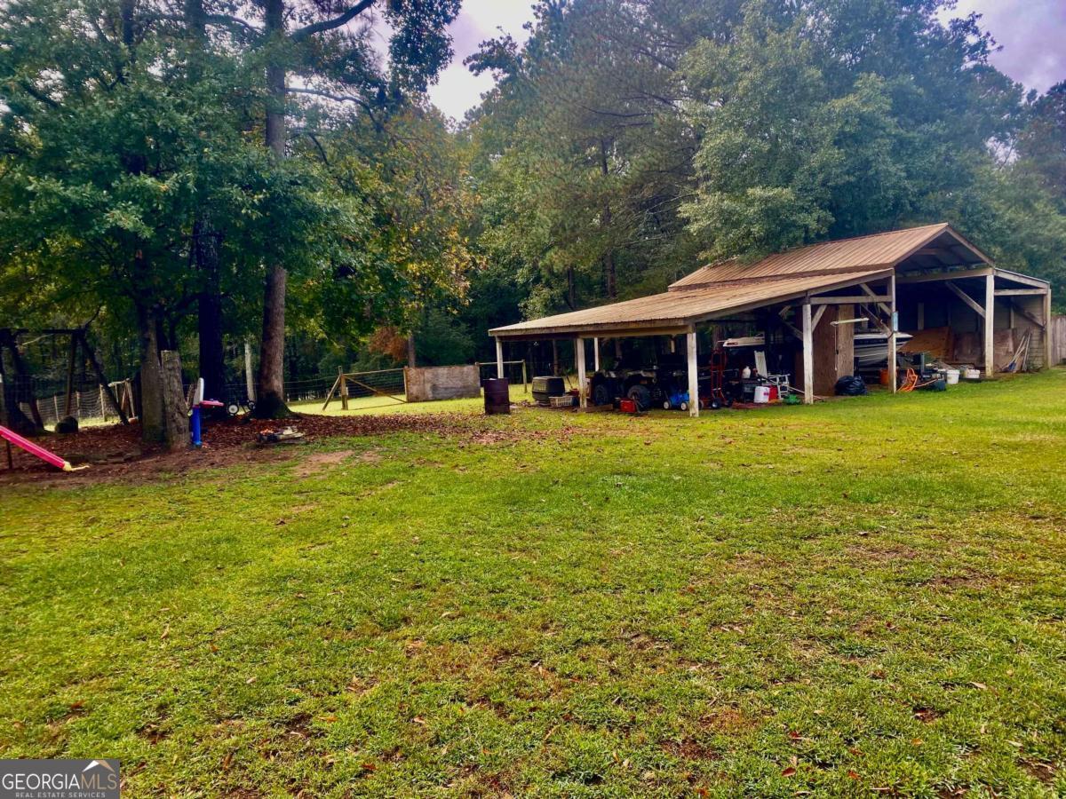 290 Poplar Creek Road Stephens, GA 30667 - Photo 23 of 68 a view of a house with a big yard and large trees