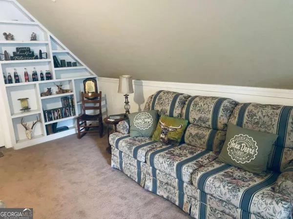 a bedroom with a bed a large window and dresser