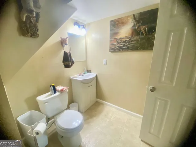 a bathroom with a granite countertop sink a toilet and a mirror