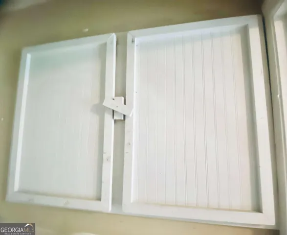 a view of hallway with paintings on the wall and a window