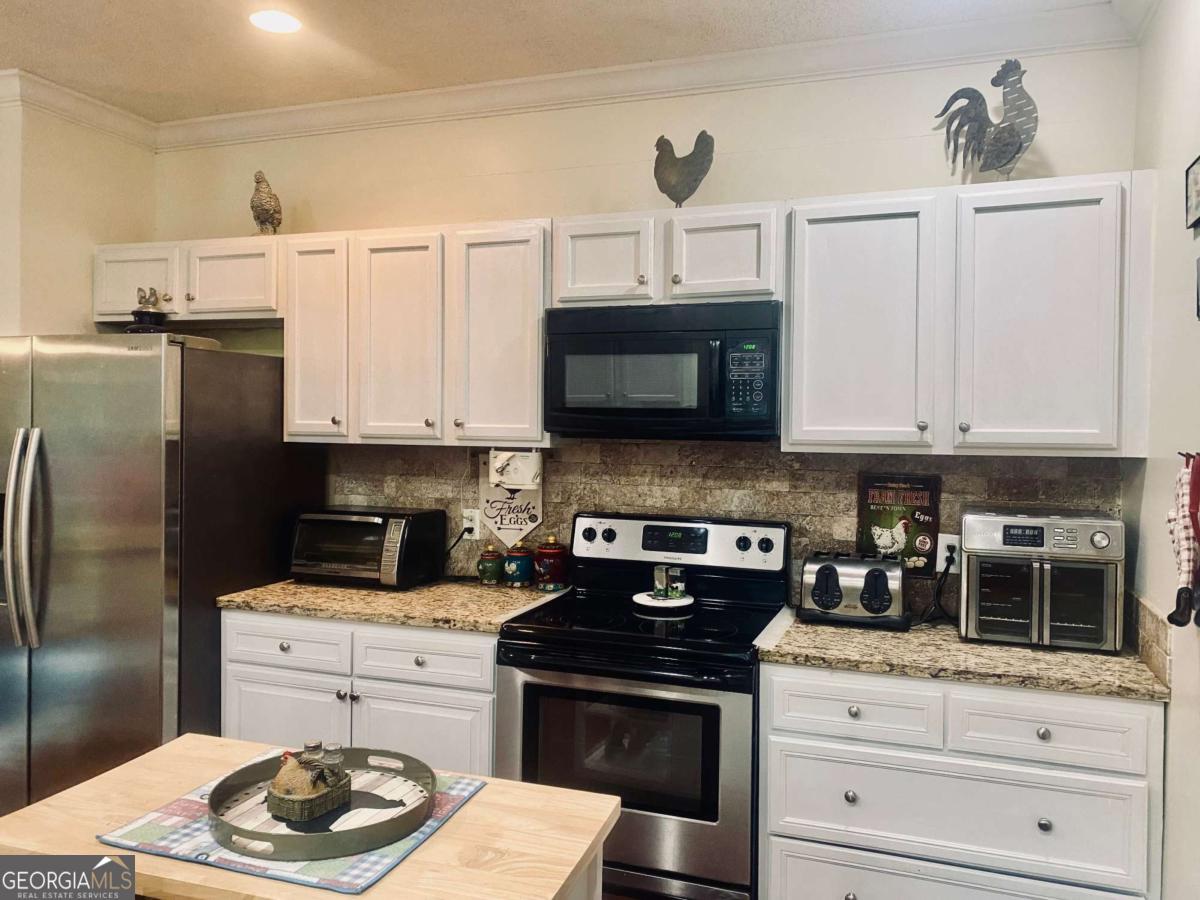 290 Poplar Creek Road Stephens, GA 30667 - Photo 58 of 68 a kitchen with appliances a sink and cabinets