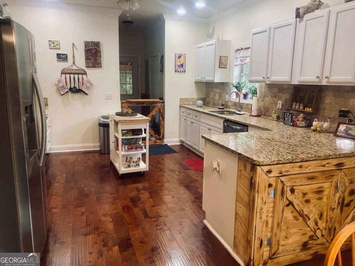 290 Poplar Creek Road Stephens, GA 30667 - Photo 61 of 68 a kitchen with stainless steel appliances granite countertop a stove a refrigerator a sink a oven with wooden cabinets and floor