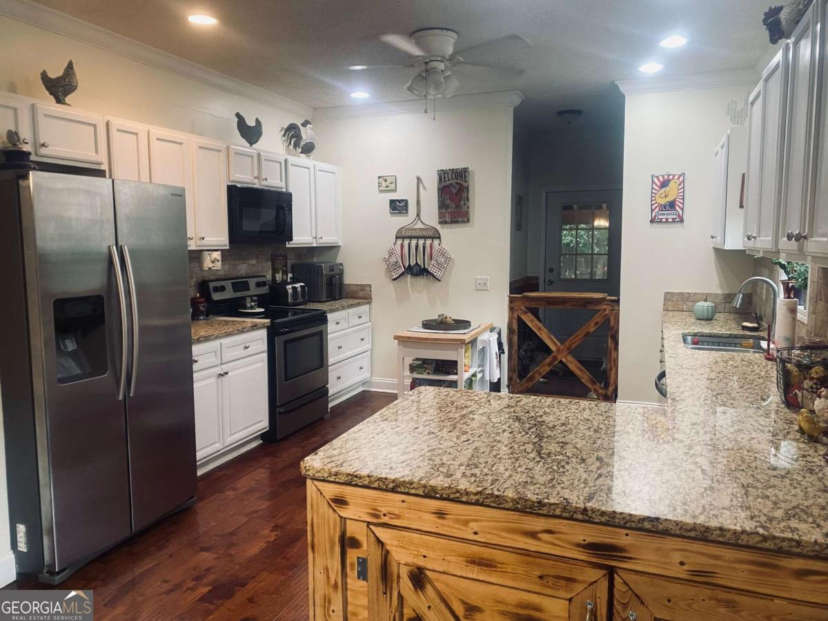 290 Poplar Creek Road Stephens, GA 30667 - Photo 62 of 68 a kitchen with stainless steel appliances granite countertop a sink a stove and a refrigerator
