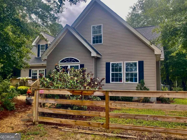 a view of a house with backyard and deck