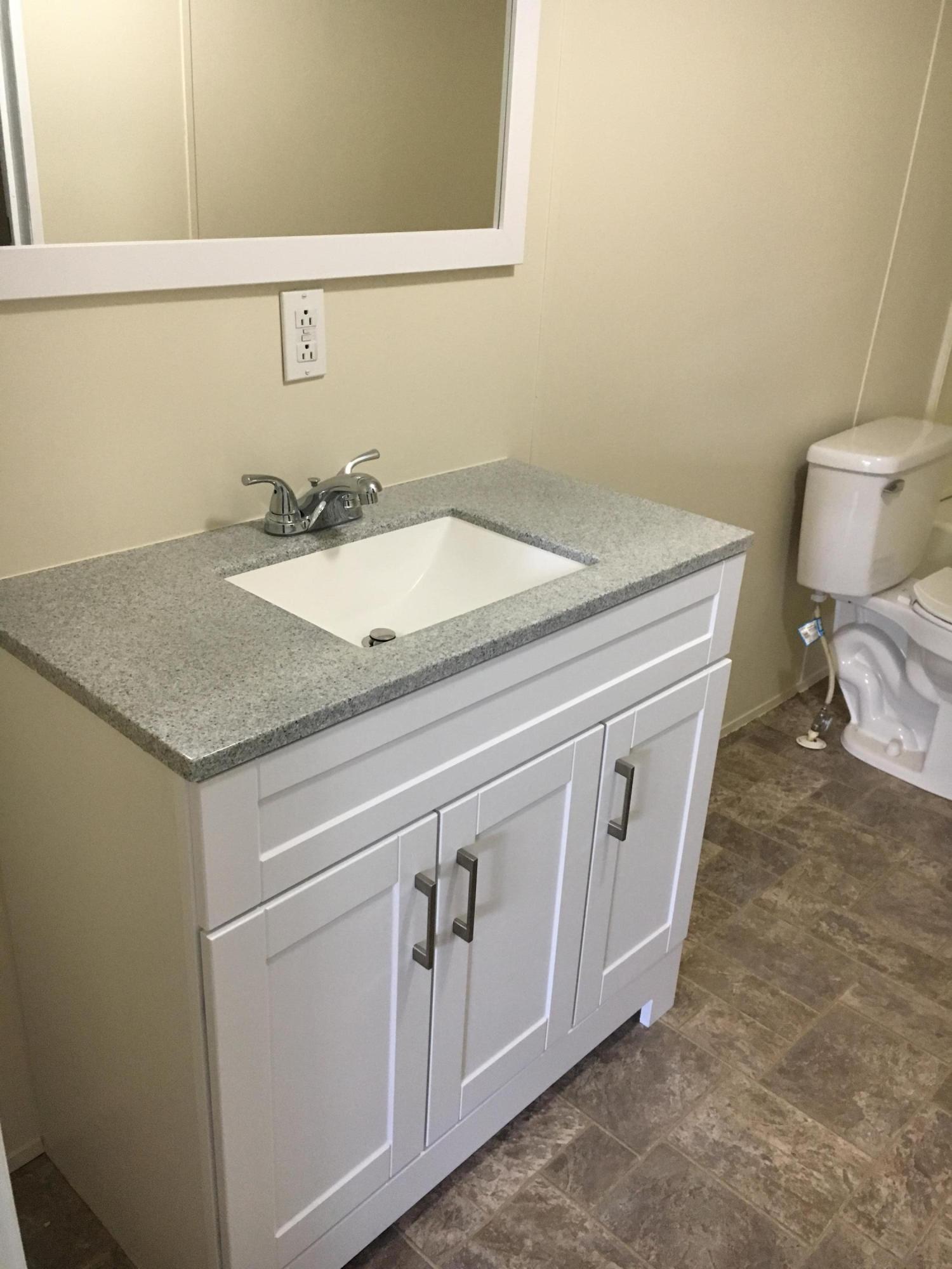 2205 Conner Grove Road Southwest Willis, VA 24380 - Photo 7 of 18 a bathroom with a granite countertop sink and a toilet