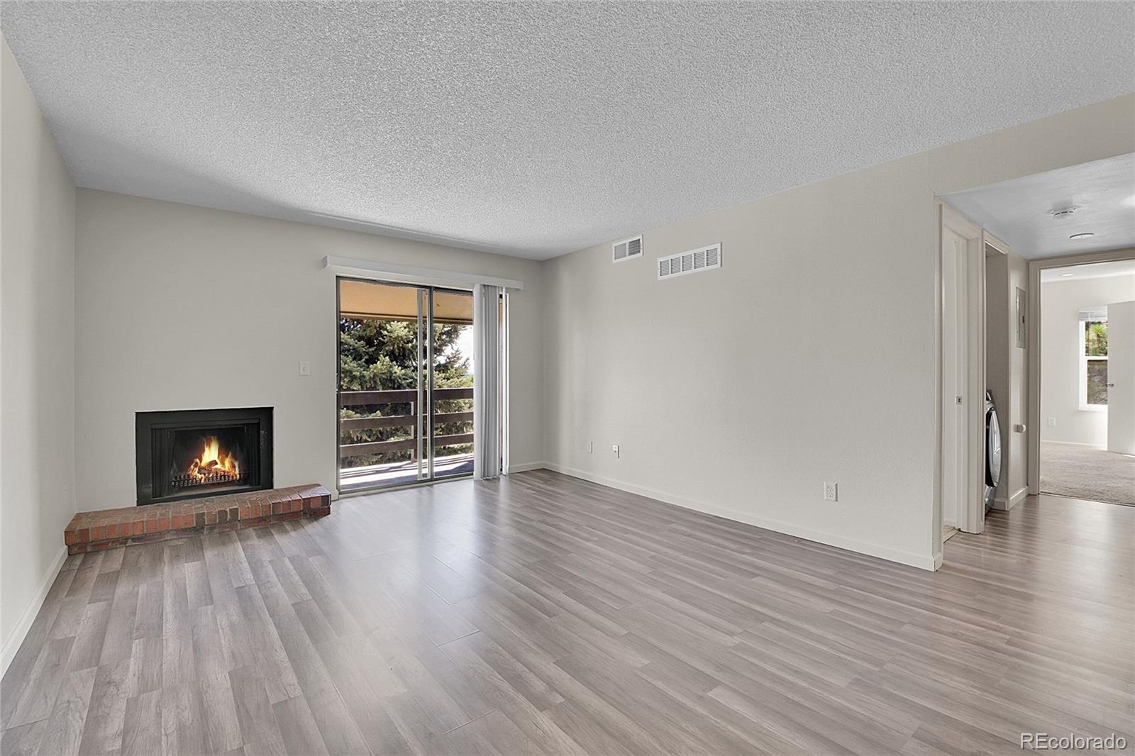539 Wright Street, Unit 301 Lakewood, CO 80228 - Photo 21 of 32 a view of an empty room with wooden floor fireplace and a window