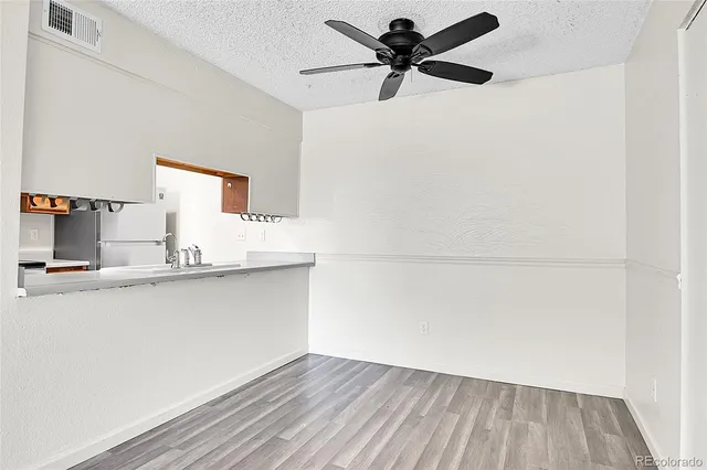 a view of a kitchen with wooden floor and a sink