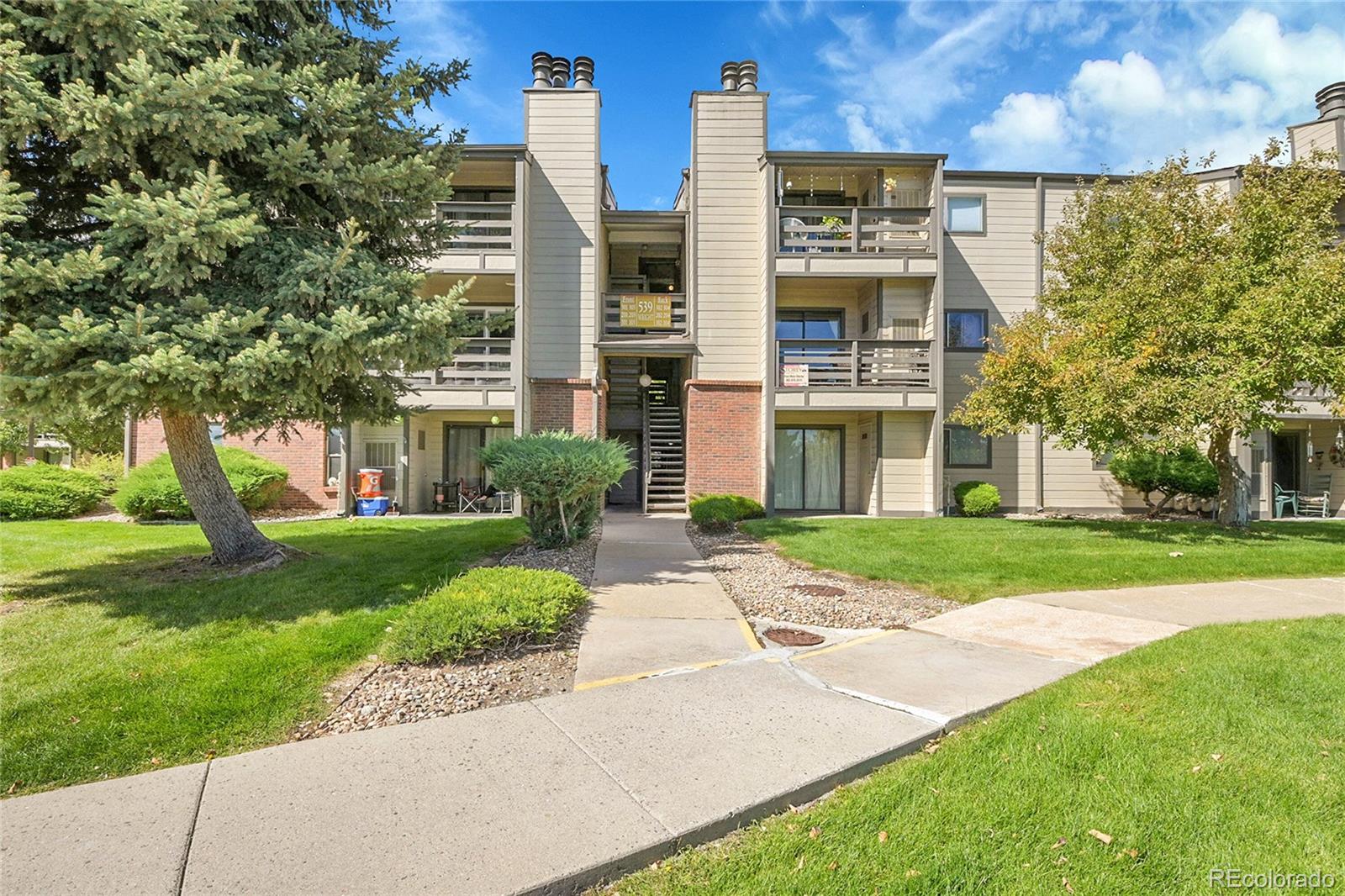539 Wright Street, Unit 301 Lakewood, CO 80228 - Photo 4 of 32 a front view of a building with a garden and plants