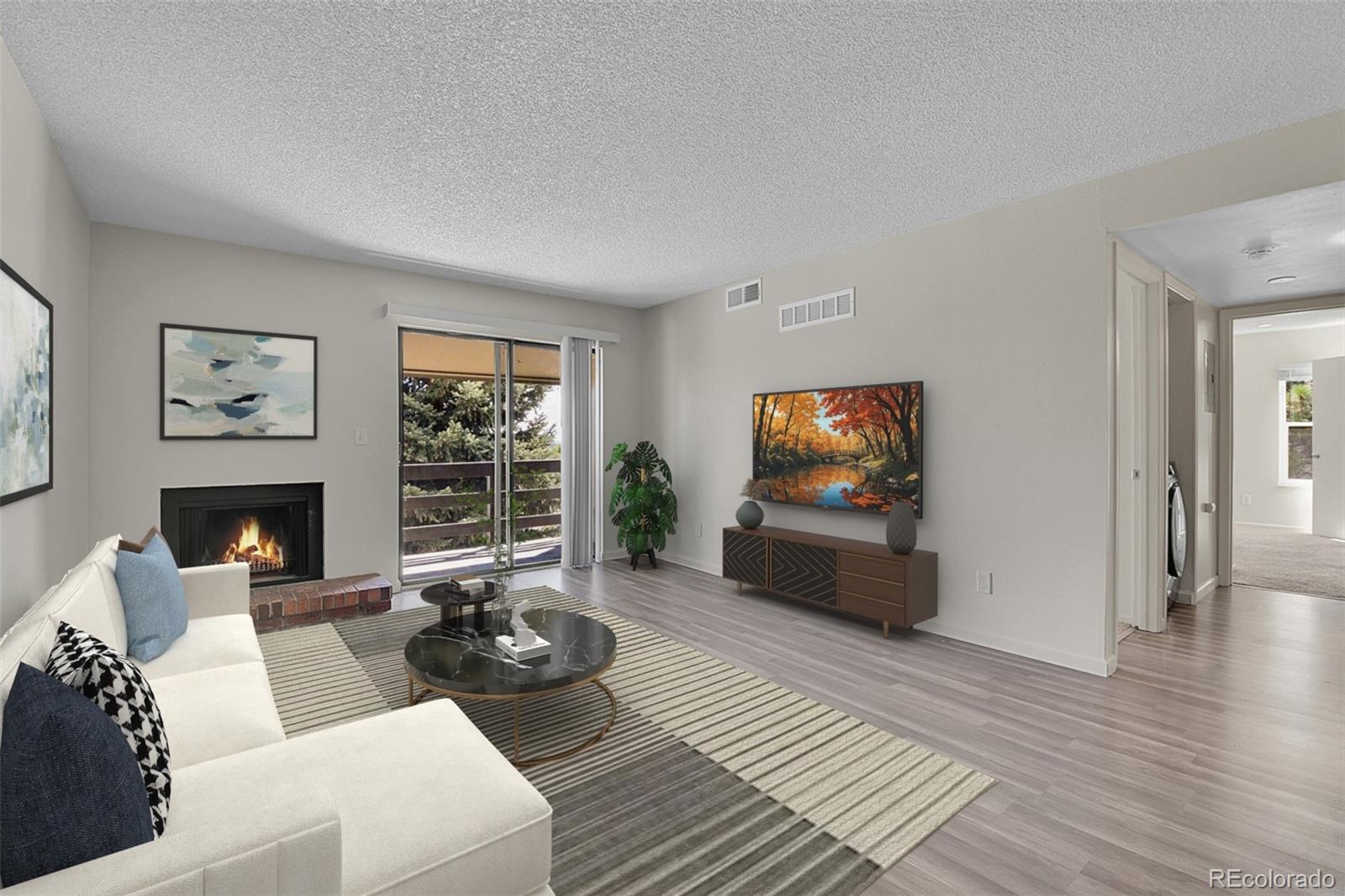 539 Wright Street, Unit 301 Lakewood, CO 80228 - Photo 5 of 32 a living room with furniture a fireplace and a flat screen tv