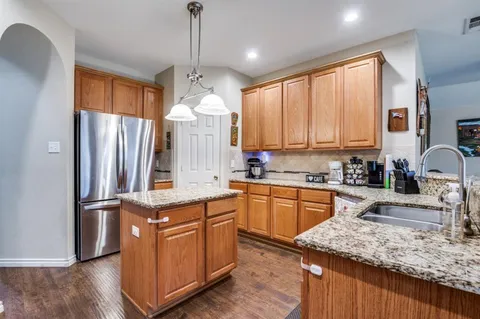 a kitchen with kitchen island granite countertop a sink appliances cabinets and counter space