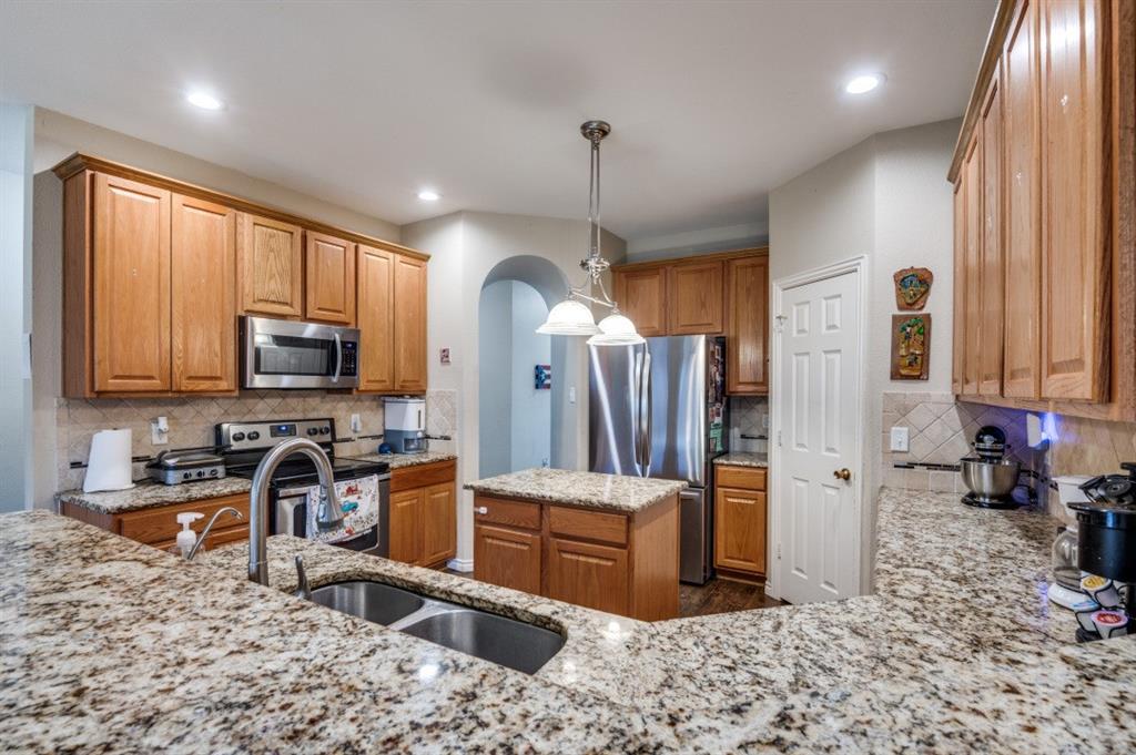 1211 Maple Terrace Drive Mansfield, TX 76063 - Photo 14 of 26 a kitchen with stainless steel appliances granite countertop a refrigerator a stove a sink dishwasher and wooden cabinets