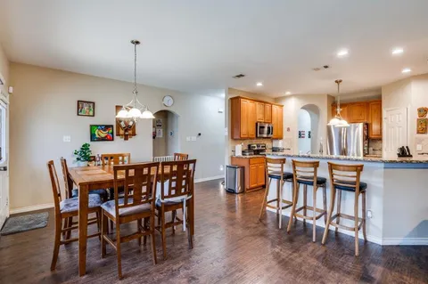 a view of a dining room and livingroom with furniture wooden floor a chandelier