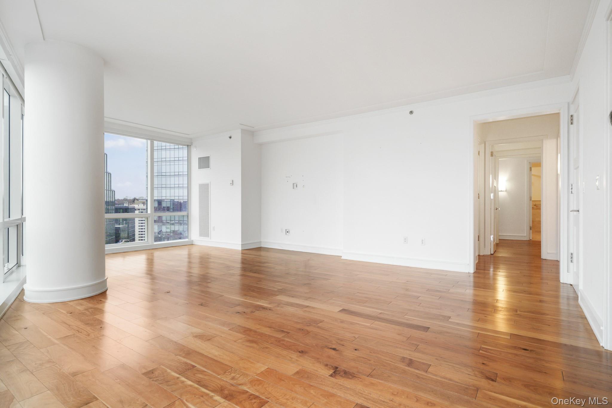 1 Renaissance Square, Unit 15E White Plains, NY 10601 - Photo 6 of 27 a view of an empty room with wooden floor and a window