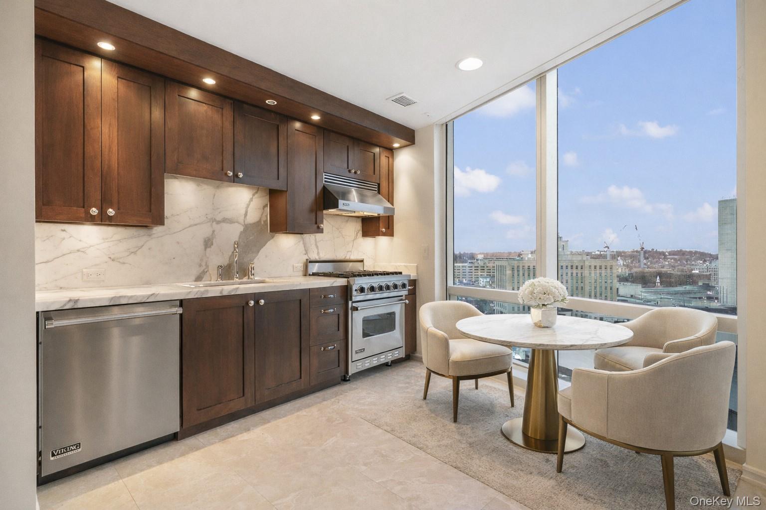 1 Renaissance Square, Unit 15E White Plains, NY 10601 - Photo 7 of 27 a kitchen with kitchen island granite countertop wooden cabinets and stainless steel appliances