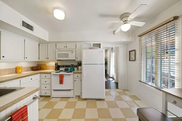 a kitchen with a white cabinets and white appliances