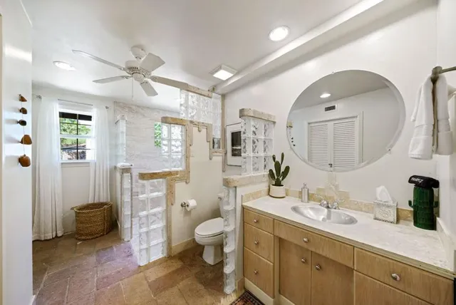a spacious bathroom with a double vanity sink toilet mirror and shower