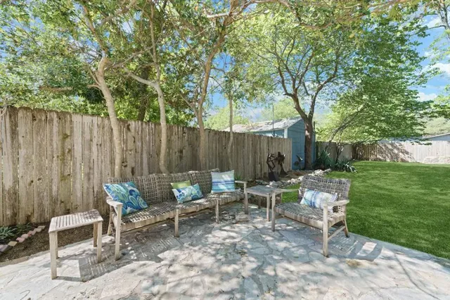 a view of backyard with seating space and trees