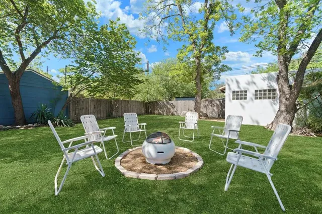a view of a chair and table in backyard of the house