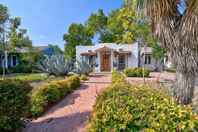 a front view of a house with a yard and fountain