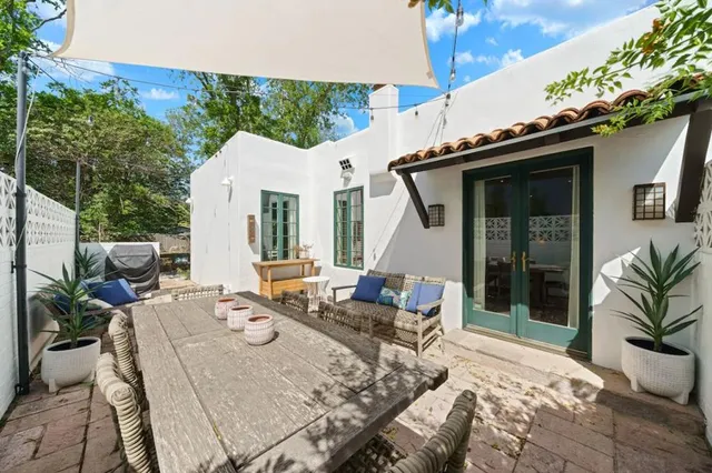 a view of a patio with table and chairs potted plants with wooden floor and fence