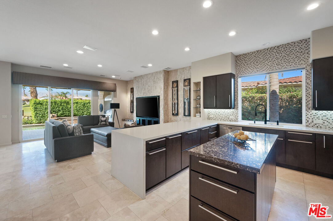 331 Tomahawk Drive Palm Desert, CA 92211 - Photo 15 of 40 a kitchen with kitchen island granite countertop a stove and a sink